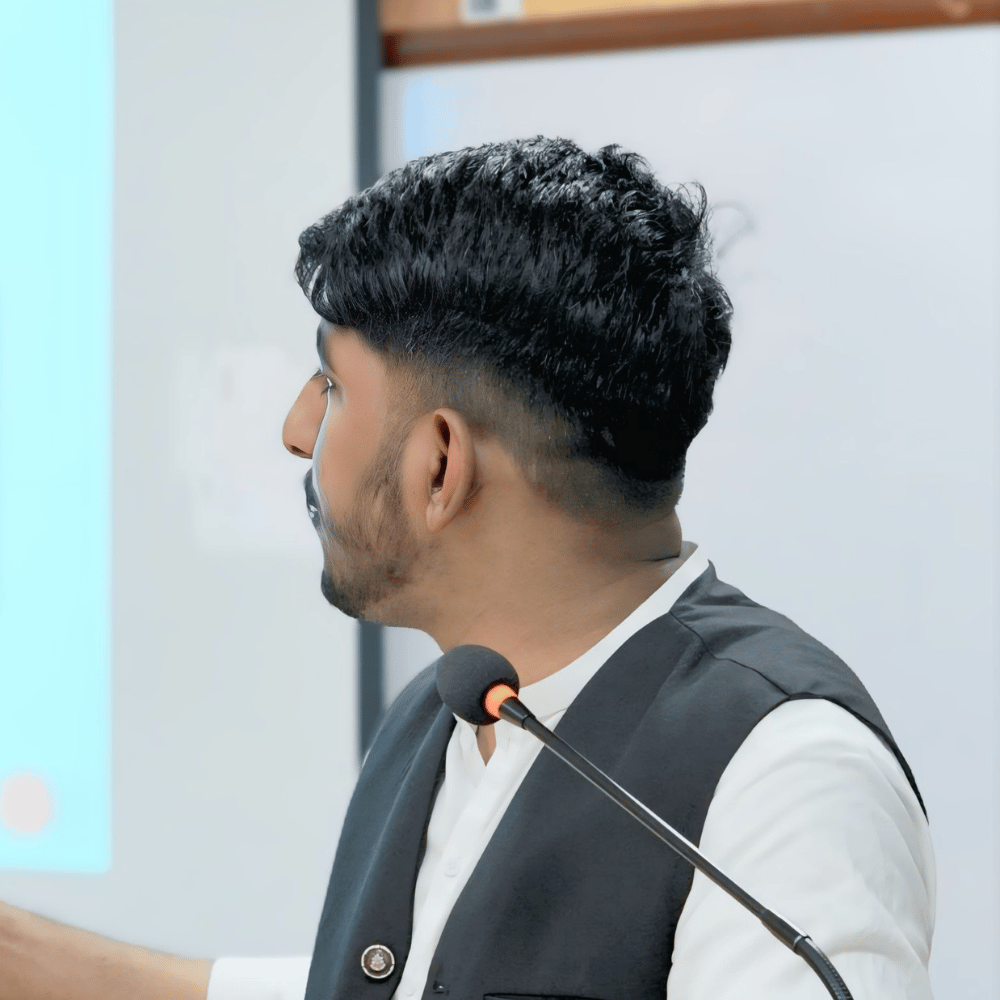 Image of a woman wearing a yellow skirt and jacket stands confidently in front of a circular door, showcasing her vibrant style.